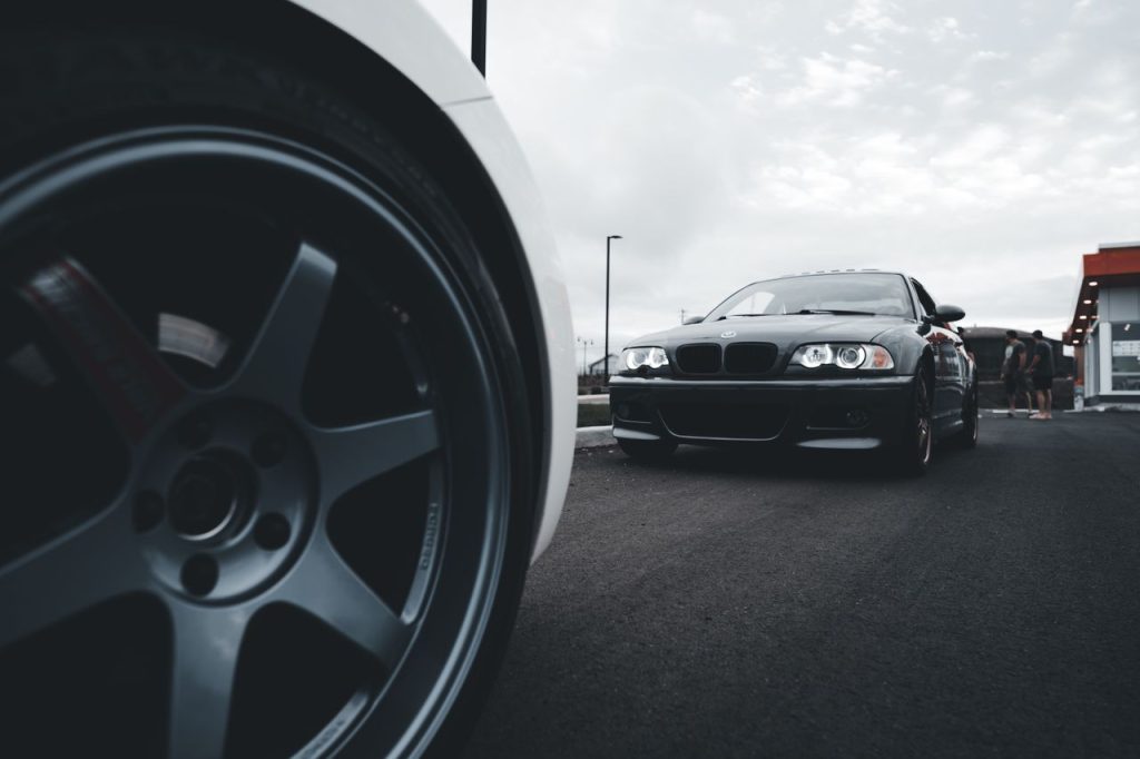 Dynamic shot of sleek sports cars on a wide asphalt road emphasizing power and speed.