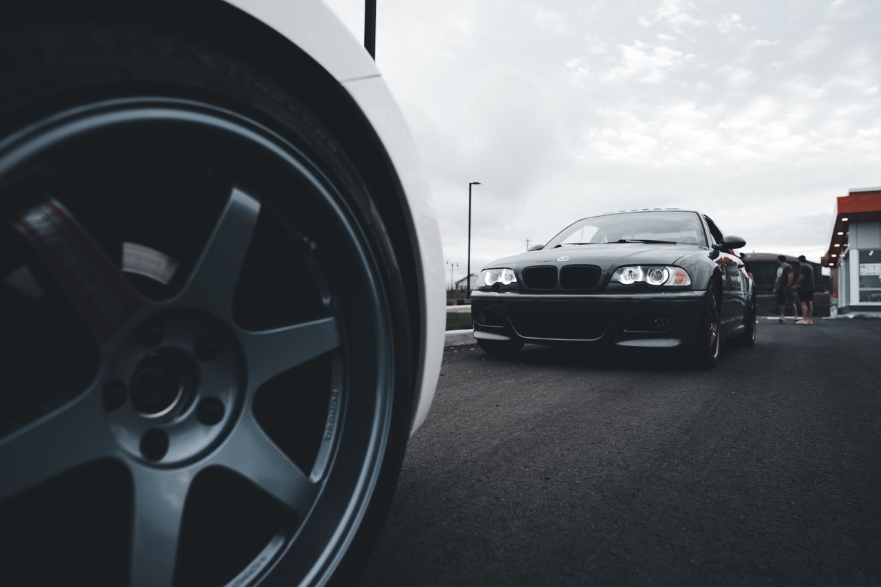 Dynamic shot of sleek sports cars on a wide asphalt road emphasizing power and speed.