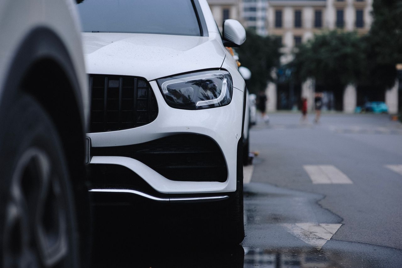 The Art of Drawing Readers In: Your attractive post title goes here Close-up view of a sleek white car parked on a city street, reflecting urban style.