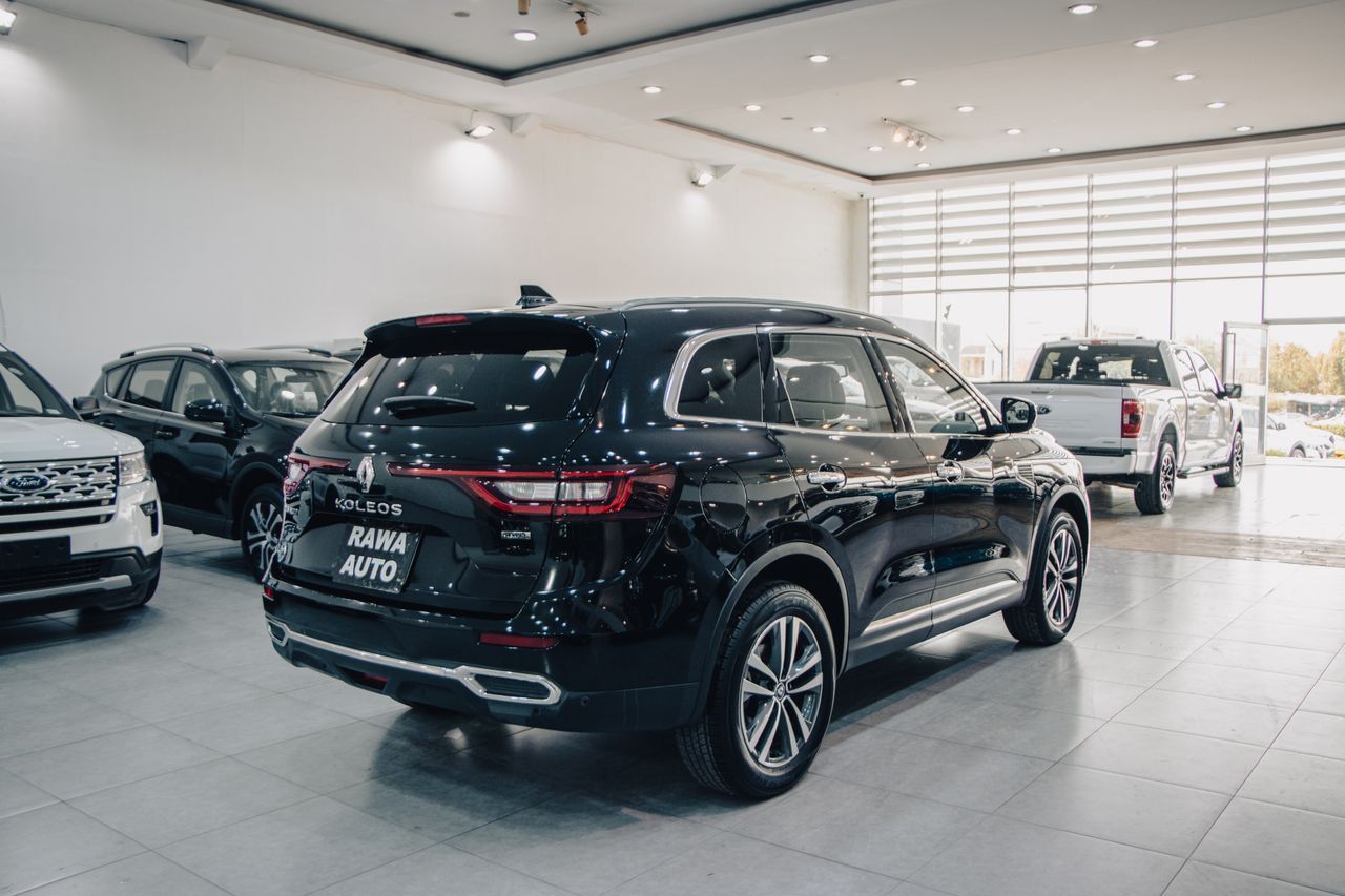 Spacious modern showroom featuring luxury cars on display.